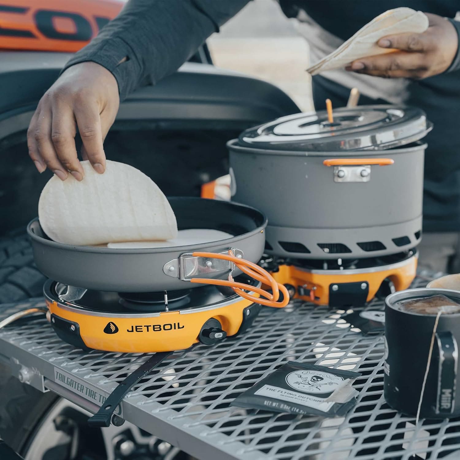 Complete Jetboil Genesis Basecamp system displayed with stove, pan, pot, windscreen, and bag